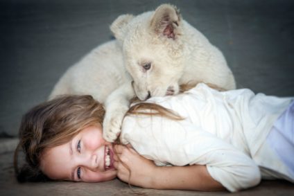 Daniah De Villiers (Mia) with lion cub Charlie during the filming @copyright Coert WiechersGalatÇe Films-Outside Films